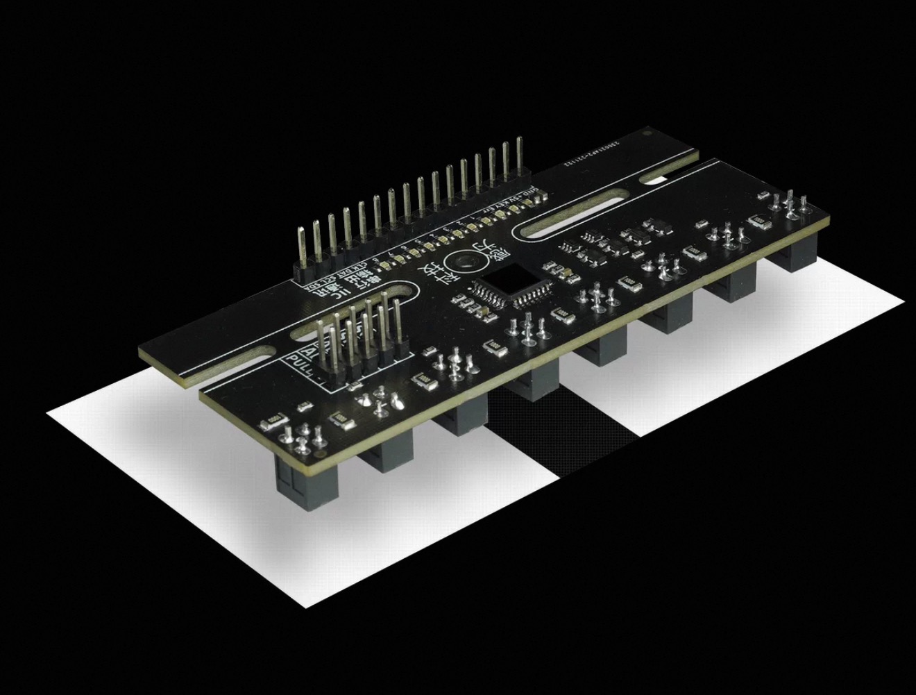 The grayscale sensor board photographed at an angle over a black-and-white boundary: one long PCB with eight downward-facing probe housings in a row along its underside, and an I2C header at one end.