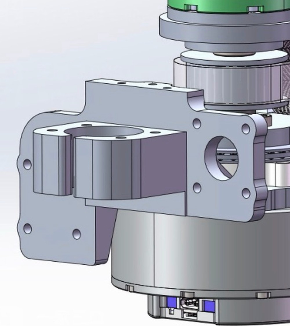 Close CAD view of the machined aluminium carriage bracket: two rail-block mounting faces set at different heights, with the joint motor and belt pulley above.