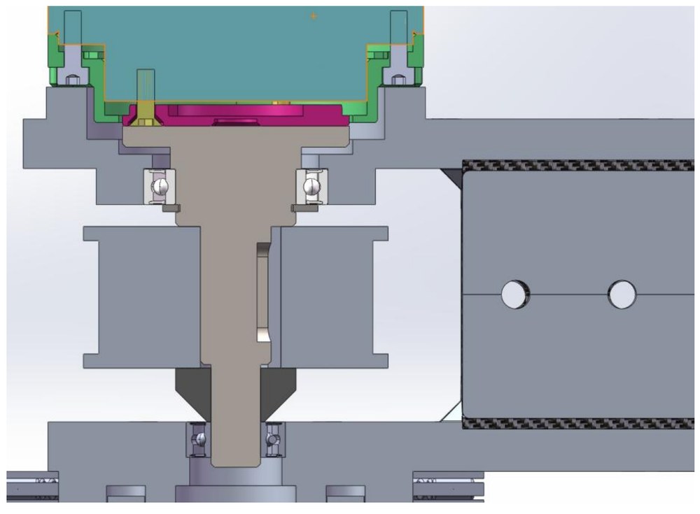 CAD section of the belt drive shaft: a stepped shaft running down the centre with a ball bearing at the top and another at the bottom, the timing-belt pulley between them, a key seat visible in the shaft, and the carbon beam entering from the right.